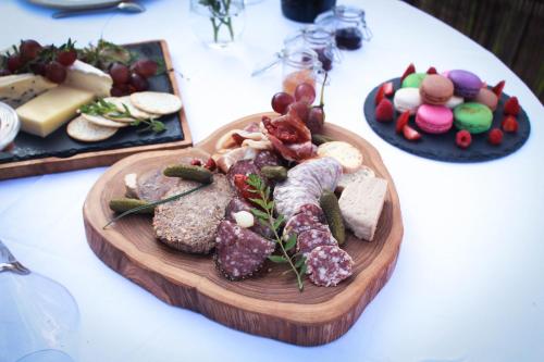 a plate of food on a table with cheese and meats at Keliki Luxury Lodge in Ubud