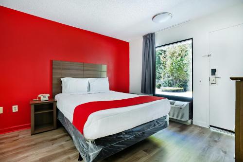 1 dormitorio rojo con 1 cama grande con pared roja en OYO Hotel Decatur I-285 The Perimeter en Decatur