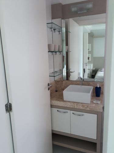 a bathroom with a sink and a mirror at Bombinhas - Residencial Atalanta 101A in Bombinhas