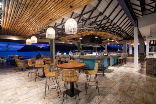 a restaurant with tables and chairs and a bar at Amaka Ocean Living Lodge in Golfito