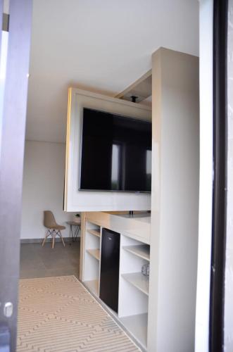 a living room with a tv on a wall at Capão do Cerrado Pousada e Spa in Itabirito