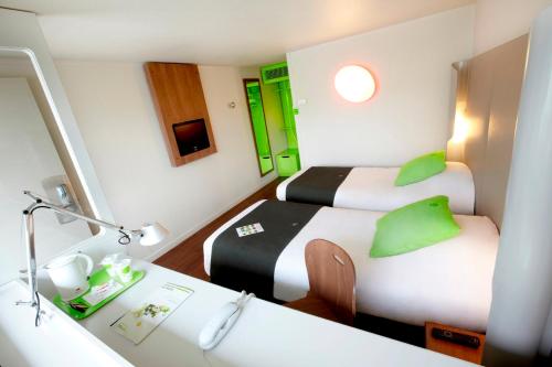 a hotel room with two beds and a desk at Campanile Toulouse Sud-Labège innopole in Labège