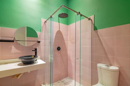 La salle de bains est pourvue d'une douche en verre, d'un lavabo et de toilettes. dans l'établissement CASA MOVIDA HOSTEL, à Carthagène des Indes