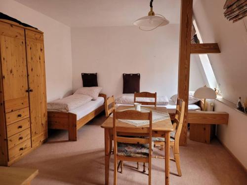 Habitación con mesa y dormitorio con 2 camas. en Jena Paradies, en Jena