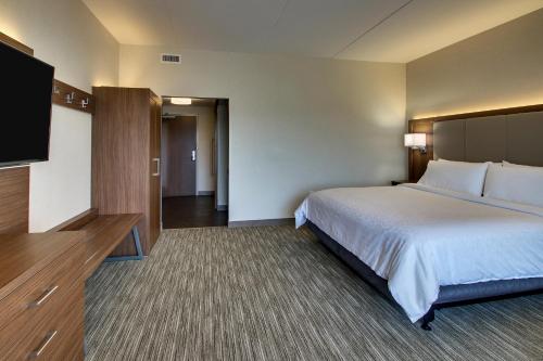 a hotel room with a bed and a flat screen tv at Holiday Inn Express & Suites Findlay North by IHG in Findlay