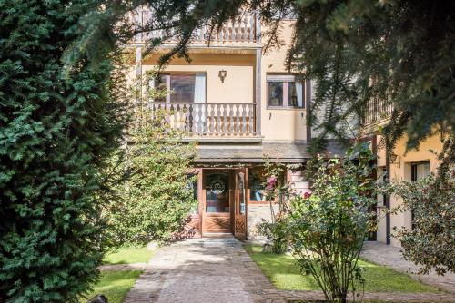 Cette maison dispose d'une porte en bois et d'un balcon. dans l'établissement El Refugio de Aran Vielha Aparthotel, à Vielha e Mijaran