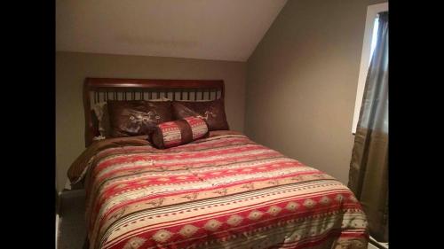 a bedroom with a bed with a comforter and a window at Cozy Mother-in-Law Apartment in Osceola