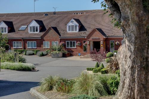a large brick house with white windows at Windmill Village Hotel, Golf Club & Spa, BW Signature Collection in Coventry