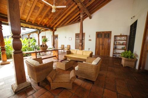 a living room with wicker furniture and a wooden ceiling at Bioma Boutique Hotel in Mompos