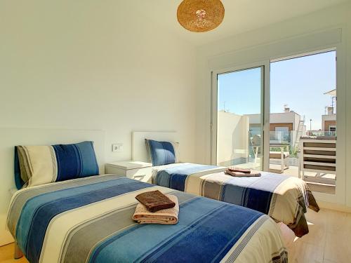 two beds in a room with a balcony at Villa Sol - San Pedro del Pinatar - 1710 in San Pedro del Pinatar