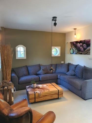a living room with a blue couch and a coffee table at B&B Resort Tremele in Dreumel