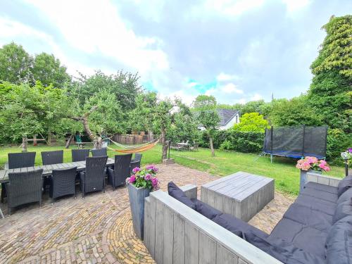 a patio with chairs and a table and a playground at B&B Resort Tremele in Dreumel