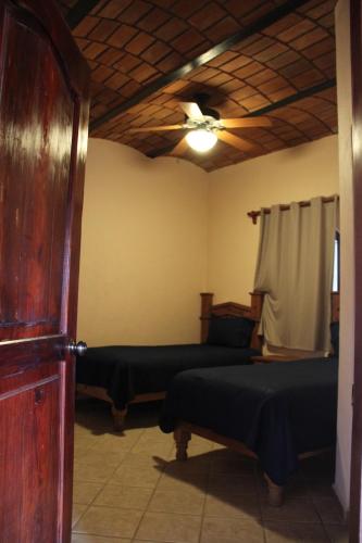 a bedroom with two beds and a ceiling fan at Villas Vista Suites Sayulita in Sayulita