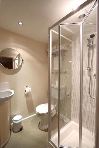 a bathroom with a shower and a toilet and a sink at Portbyhan Hotel in Looe