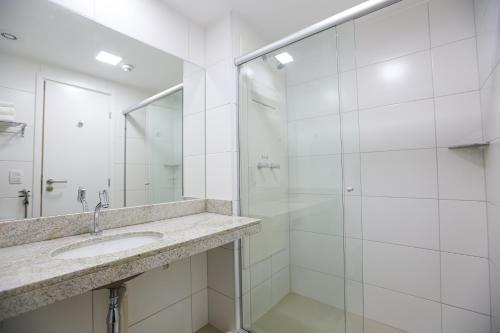 a white bathroom with a sink and a shower at Transamerica Fit Recife in Recife