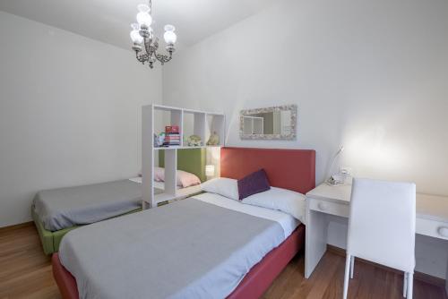 a small bedroom with a bed and a desk at ForliHouse in Forlì