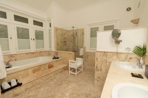 a large bathroom with a tub and a sink at Tortuga Bay in Punta Cana