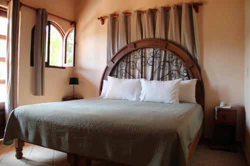 a bedroom with a large bed with a wooden headboard at Villas Vista Suites Sayulita in Sayulita
