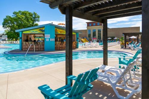 a swimming pool with chairs and a restaurant at Bridges Bay Resort in Arnolds Park