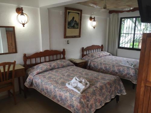 a hotel room with two beds with towels on them at Arcos hotel in Catemaco