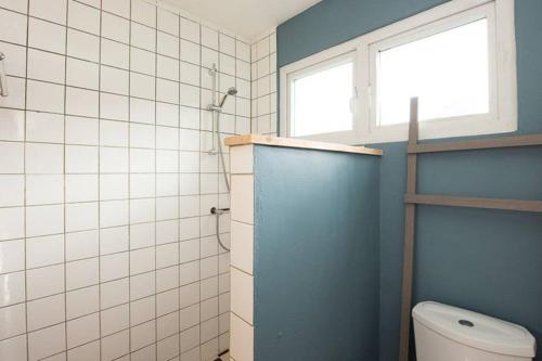 a bathroom with a toilet and a window at Smileys Apartment in Willemstad