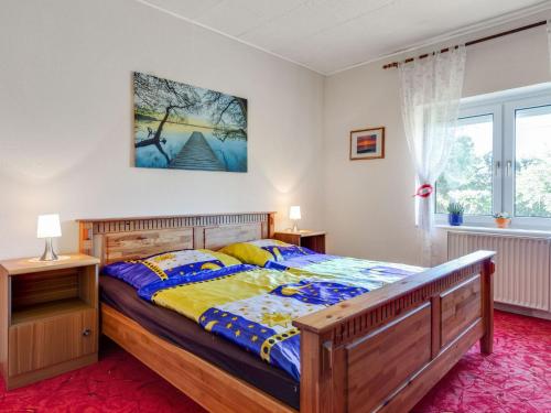 a bedroom with a wooden bed and a window at Cozy Farmhouse in Benenden with Terrace in Teßmannsdorf