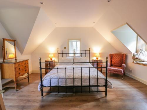 ニュートン・スチュワートにあるThe Coach Houseのベッドと椅子のある寝室