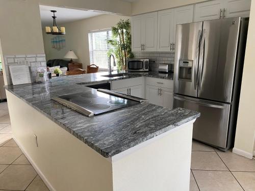 a kitchen with a granite counter top and a stainless steel refrigerator at Shorewalk 2 Bedroom 2 Bathroom Near IMG And Bradenton Beach in Bradenton