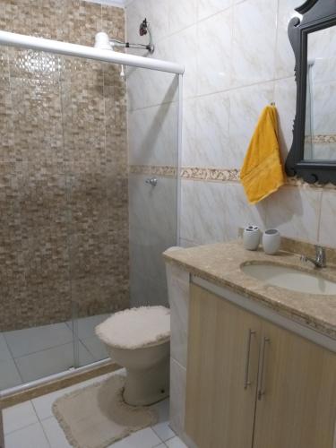 a bathroom with a shower and a toilet and a sink at CASA DE FÉRIAS PRAIANA in Cabo Frio