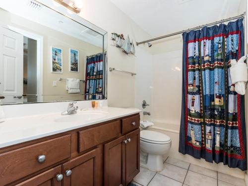 uma casa de banho com um lavatório, um WC e uma cortina de chuveiro. em Summerwind em Navarre
