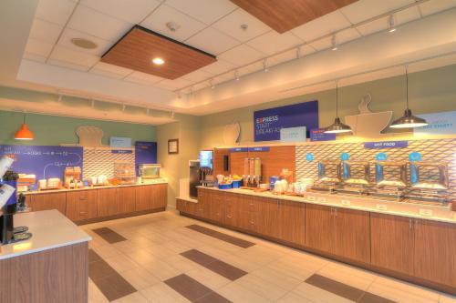 a restaurant with a large counter and a large window at Holiday Inn Express Hotel & Suites Mobile Saraland, an IHG Hotel in Saraland