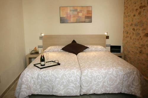 a bedroom with a white bed with a bottle of wine on it at Sa Posada in Porreres