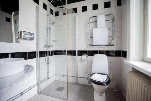 a bathroom with a shower and a toilet and a sink at The Vault Hotel, WorldHotels Crafted in Helsingborg