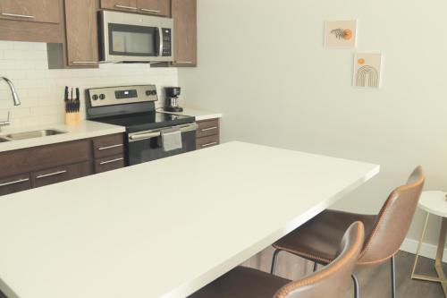 a kitchen with a counter top and chairs in it at Sleepover Premier Downtown Des Moines Apartments in Des Moines