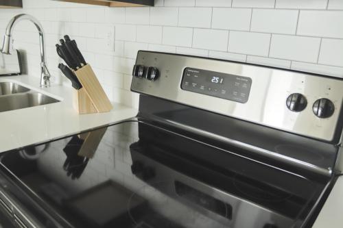 a stove top oven in a kitchen with a sink at Sleepover Premier Downtown Des Moines Apartments in Des Moines