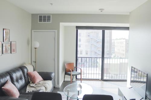 a living room with a couch and a table at Sleepover Premier Downtown Des Moines Apartments in Des Moines