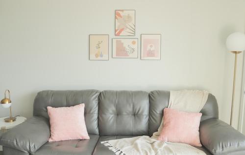 a gray couch with pink pillows in a living room at Sleepover Premier Downtown Des Moines Apartments in Des Moines