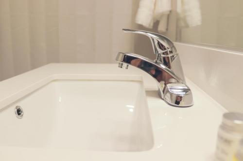 a bathroom sink with a chrome bathroom faucet at Sleepover Premier Downtown Des Moines Apartments in Des Moines