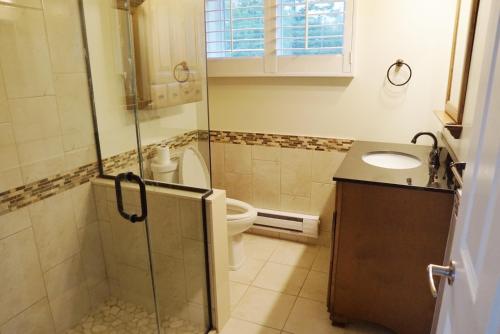 y baño con aseo, lavabo y ducha. en Entire waterfront cottage in carrying place en Carrying Place
