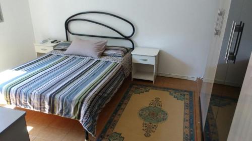 a small bedroom with a bed and a rug at Flat Tacaunas in Sao Paulo