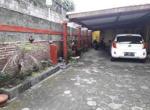 a white car is parked in a garage at Hotel Kayu Manis in Kaliurang