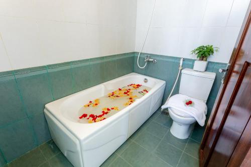 a bathroom with a bath tub and a toilet at Amigo Hue Hotel in Hue