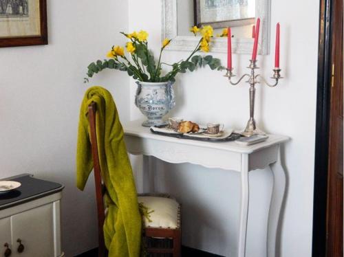 a table with a plate of food and a vase with candles at Art&Kitchen in Savona