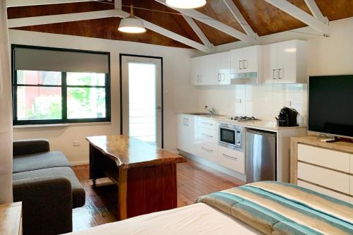 a room with a kitchen and a living room at Airlie Beach Magnums - Adults Only in Airlie Beach