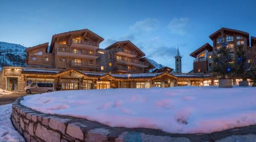 a large lodge with a pile of snow in front of it at CGH Résidences & Spas Kalinda in Tignes