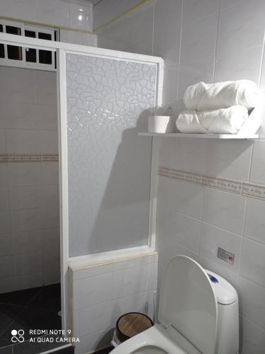 a bathroom with a toilet and towels on a shelf at SWEET BREEZE in San Andrés