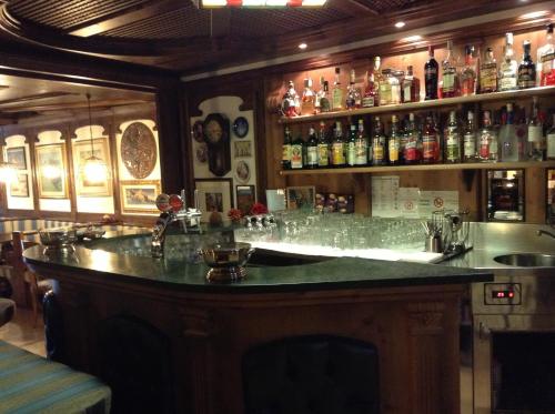 a bar with a lot of glasses on the counter at Hotel Ai Pini in Vigo di Fassa