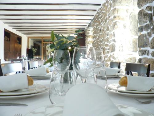 a table with wine glasses and plates on it at Goiko-Benta Ostatua in Oñate