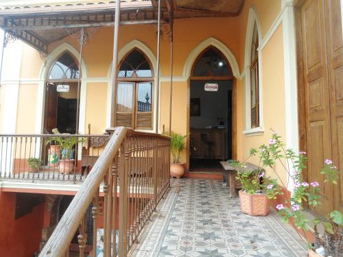 a porch of a building with a staircase and plants at Pousada Estação do Trem in São João del Rei