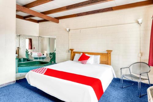 ein Schlafzimmer mit einem großen weißen Bett und einer Badewanne in der Unterkunft OYO Oasis Motel Las Vegas I-15 in Las Vegas